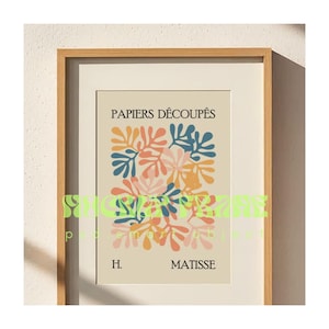 May include: A framed art print featuring a colorful abstract design of leaf-like shapes in shades of blue, orange, and pink. The print is titled "PAPIERS D&Eacute;COUP&Eacute;S" and signed "H. MATISSE". The artwork is displayed in a wooden frame.