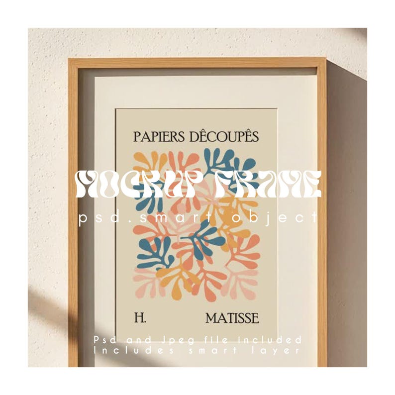 May include: A framed art print featuring a colorful abstract design of leaf-like shapes in blue, orange, and pink. The print is titled "PAPIERS D&Eacute;COUP&Eacute;S" and signed "H. MATISSE". The frame is made of light-colored wood.