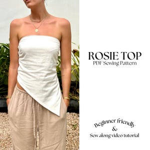 May include: A white strapless top with a diagonal cut at the bottom. The top is made of a lightweight fabric and has a relaxed fit. The text "ROSIE TOP PDF Sewing Pattern" is displayed on a white background. The text "Beginner friendly & Sew along video tutorial" is displayed on a white background.