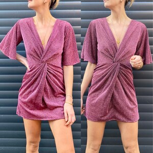 Peut inclure: Une robe courte rose paillet&eacute;e avec un col en V et un n&oelig;ud &agrave; la taille.
