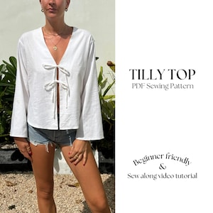 May include: A white, long-sleeved top with a deep V-neck and a tie detail at the front. The top is cropped and has a relaxed fit. The text "TILLY TOP" and "PDF Sewing Pattern" is visible in the image. The text "Beginner friendly & Sew along video tutorial" is also visible in the image.