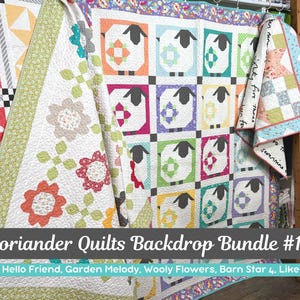 May include: A collection of colorful quilts, including one with sheep designs in squares and another with floral patterns. The quilts are displayed on a wooden rack. The text "Coriander Quilts Backdrop Bundle #15" is visible.