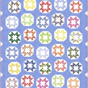 Op de afbeelding: Een handgemaakte quilt met een lichtblauwe achtergrond en een geschulpte rand. De quilt heeft een herhalend patroon van achthoeken met stervormige centra in verschillende kleuren en patronen, waaronder bloemen en ruitjes.