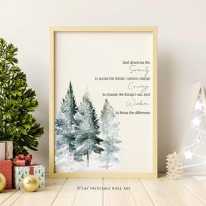 May include: A framed 8x10 inch printable wall art print with a watercolor image of evergreen trees. The print has the Serenity Prayer in elegant script. Christmas decorations, including a tree and gifts, are in the background.