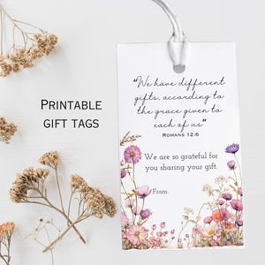 Könnte beinhalten: Druckbare Geschenkanhänger mit floralem Aquarelldesign. Die Anhänger zeigen ein Zitat aus Römer 12,6 und Platz zum Schreiben von "Von:". Getrocknete Blumen sind um die Anhänger verstreut.