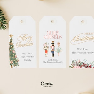 Könnte beinhalten: Drei weiße Weihnachtsgeschenkanhänger mit festlichen Designs. Einer zeigt einen Weihnachtsbaum, ein anderer Nussknackerfiguren und der letzte florale Akzente. Jeder Anhänger trägt die Aufschrift „Merry Christmas“ und „With love, The Freeman Family“.