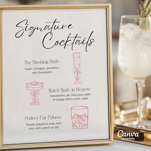May include: A gold-framed sign with the words "Signature Cocktails" in cursive. The sign lists three cocktail recipes with illustrations: "The Blushing Bride," "Match Made in Heaven," and "Perfect Pair Paloma."