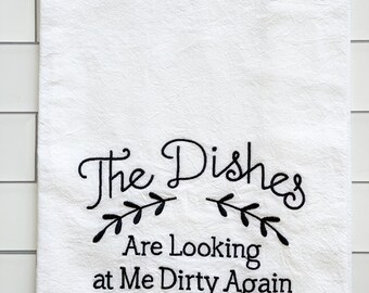 May include: White kitchen towel with black embroidered text that reads "The Dishes Are Looking at Me Dirty Again".