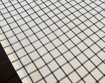 May include: White table runner with a black and white checkered pattern.