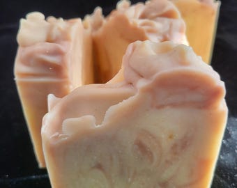 May include: Three bars of handmade soap with a swirl pattern in shades of beige and light pink. The soap is made with natural ingredients and is perfect for sensitive skin.