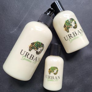 May include: Three bottles of lotion with a white background and a green and black logo that says "URBAN Goddess 330".
