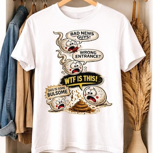 May include: White t-shirt with a humorous graphic featuring sperm cells with speech bubbles. The text includes "BAD NEWS GUYS!", "WRONG ENTRANCE?", "WTF IS THIS!", and "THIS IS SOME BULSOME". The design is a cartoon style.