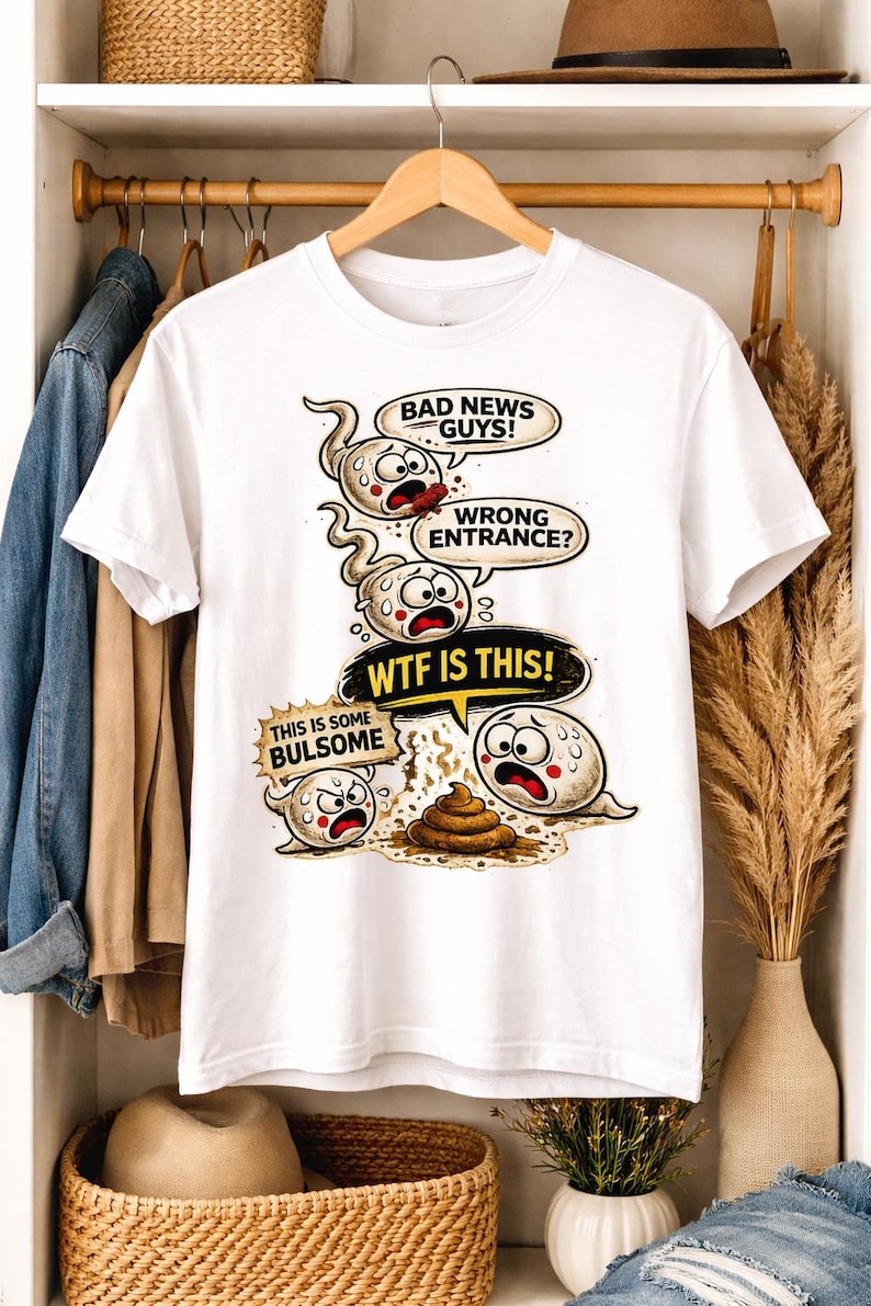 May include: White t-shirt with a humorous graphic featuring sperm cells with speech bubbles. The text includes "BAD NEWS GUYS!", "WRONG ENTRANCE?", "WTF IS THIS!", and "THIS IS SOME BULSOME". The design is a cartoon style.