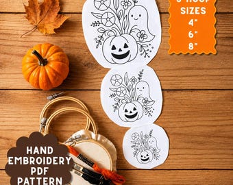 May include: A hand embroidery PDF pattern kit featuring three white fabric circles with black line art of a ghost, pumpkin, and flowers. Includes three wooden embroidery hoops, orange and black embroidery floss, and text: 3 HOOP SIZES 4" 6" 8".
