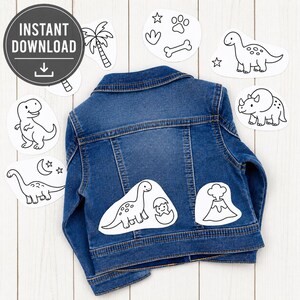 May include: A blue denim jacket with several white dinosaur-themed iron-on patches. The patches include various dinosaur illustrations, a volcano, and a palm tree. The words "INSTANT DOWNLOAD" are in a black circle.