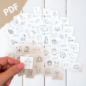 May include: A collection of small, square cards with black and white illustrations of woodland creatures and plants. The cards are scattered on a white wooden surface. The word "PDF" is visible in the upper left corner.