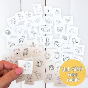 May include: A collection of small, square fabric patches with black line drawings of woodland creatures and plants. The patches include images of a deer, bear, fox, squirrel, and more. The text "Stick + Stitch mini motifs" is in a yellow circle.