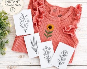 May include: A coral-colored ribbed baby bodysuit with ruffled sleeves and a sunflower embroidery, accompanied by four white rectangular cards featuring black line art illustrations of various wildflowers, including a bellflower and daisy.