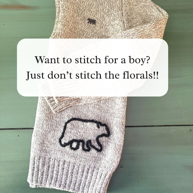 May include: A light beige knit fabric featuring a dark brown embroidered bear silhouette. The fabric displays the text: Want to stitch for a boy? Just don't stitch the florals!! The knit material has a ribbed texture at the bottom edge.