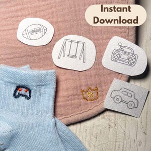 May include: Light blue socks with a dark blue embroidered game controller, a pink muslin fabric with a gold crown embroidery, and four white patches featuring line art of a football, a swing set, a boombox, and a car. Text reads Instant Download.