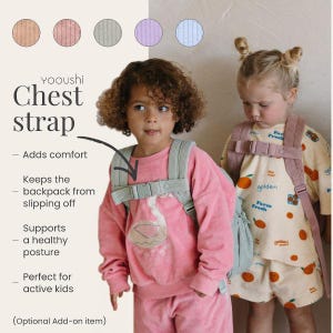 May include: Two young children wearing backpacks with chest straps. The straps are light green and have a corduroy texture. The text on the image says "Chest strap" and "Adds comfort". The children are wearing pink and cream-colored outfits.