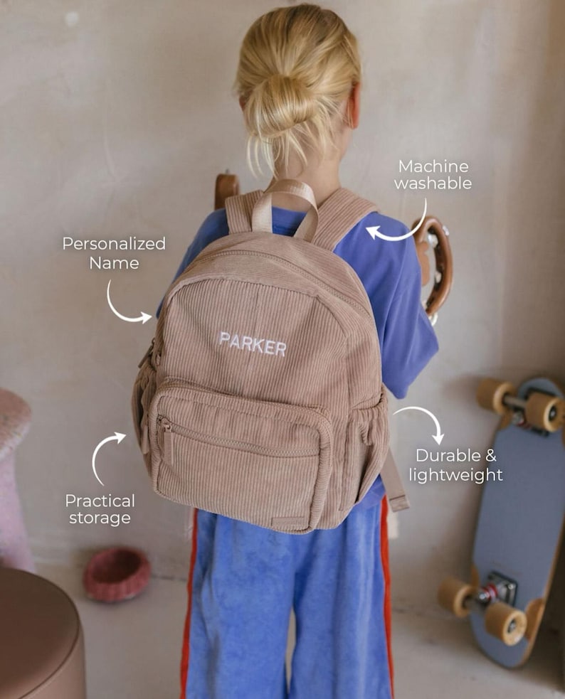May include: A tan corduroy backpack with the name "PARKER" embroidered in white. The backpack has a front pocket and adjustable straps. Features include practical storage, machine washability, and a durable, lightweight design.