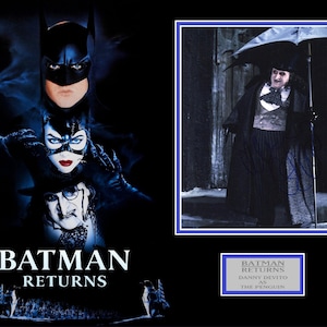 May include: A movie poster for Batman Returns featuring Batman, Catwoman, and The Penguin. The Penguin is shown in a separate image with a black umbrella and a tuxedo. The text on the poster reads "Batman Returns".