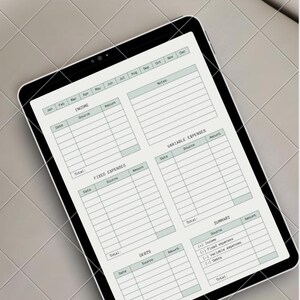 May include: A digital tablet displaying a "BASIC BUDGET PLANNER" layout. The screen features sections for income, fixed expenses, variable expenses, debts, and a summary, all in a minimalist design with a light green and white color scheme.