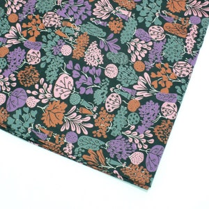May include: A dark green fabric with a repeating pattern of stylized plants and flowers in shades of pink, purple, brown, and green.