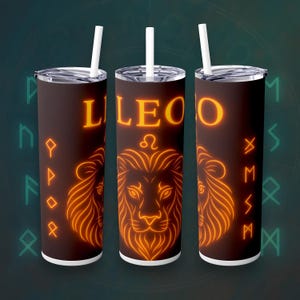 Puede incluir: Un juego de tres vasos Leo marrones con pajitas blancas. Cada vaso presenta un diseño de león naranja brillante, la palabra "LEO" y símbolos astrológicos. El fondo es verde oscuro con runas.