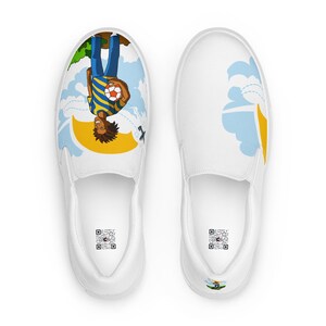 May include: White slip-on shoes with a colorful cartoon design. One shoe features a person holding a soccer ball, with a blue and yellow striped shirt, and blue jeans. The other shoe has a cloud and sun design. Both shoes have a QR code.