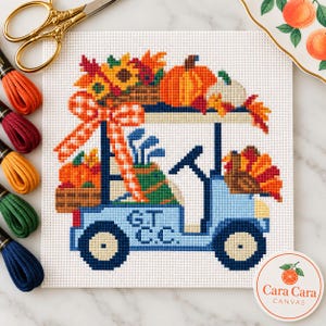 Könnte beinhalten: Eine Stickvorlage mit einem hellblauen Golfwagen, der an der Seite den Text G.T. C.C. trägt. Der Wagen ist mit einem orangefarbenen Kürbis, Sonnenblumen, Herbstblättern und einer karierten Schleife verziert, dazu ist eine Golftasche zu sehen.