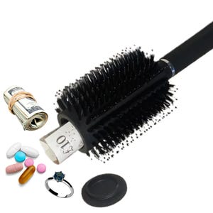 Peut inclure: Une brosse à cheveux noire avec un compartiment caché. Le compartiment est ouvert et montre un rouleau de billets, une bague et des pilules. La brosse a un manche noir et une tête de brosse ronde.