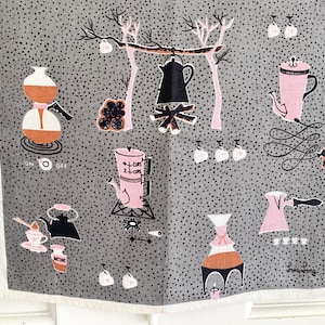 May include: Gray and white vintage kitchen towel with a repeating pattern of coffee-making equipment in black, pink, and orange. The design includes coffee pots, cups, and a campfire scene. The towel has a white border.