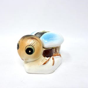 May include: A set of three ceramic mugs with a speckled, matte finish. The mugs are in shades of cream, light gray, and dark gray. Each mug has a simple, minimalist design, perfect for coffee or tea.