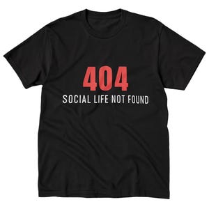 Könnte beinhalten: Schwarzes T-Shirt mit dem Text "404 SOCIAL LIFE NOT FOUND" in Rot und Weiß. Das Rundhals-Shirt hat ein schlichtes Design mit zentriertem Text. Der Stoff scheint weich und bequem zu sein.