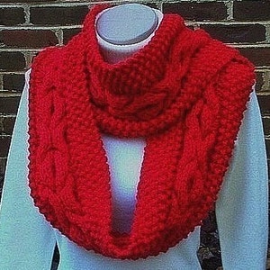 May include: A vibrant red, cable-knit infinity scarf. The scarf is displayed on a white mannequin, showcasing its thick, textured weave and intricate cable design. The scarf is made of a soft, warm material.