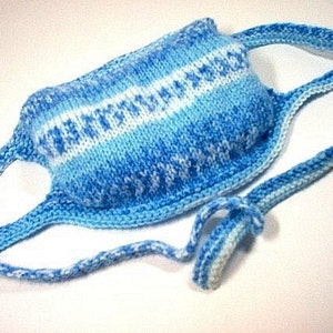 May include: A blue and white knitted face mask with a long strap. The mask has a striped pattern with white and blue yarn.