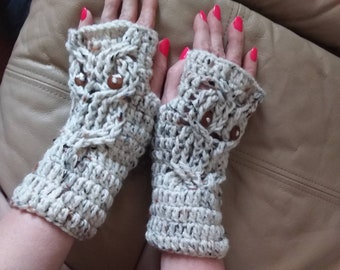 May include: A pair of beige crocheted fingerless gloves with brown button accents. The gloves have a textured pattern and are made with a speckled yarn.