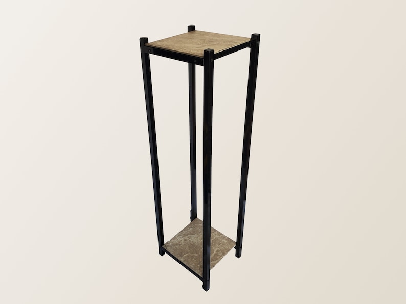 May include: A tall, black metal plant stand with a square top and a lower shelf. The top and shelf have a textured, light brown surface. The stand is designed with a minimalist aesthetic, suitable for displaying plants or decorative items.