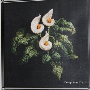 May include: White embroidered calla lilies with green leaves on a black background. Design area is 3 inches by 3 inches.