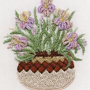 May include: Embroidered image of a bouquet of purple, pink, and yellow irises in a brown and beige woven basket.