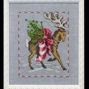 May include: A cross-stitch pattern featuring a reindeer pulling a Christmas tree with a red bow and candy cane. The reindeer is brown with white antlers and is running through a snowy landscape.