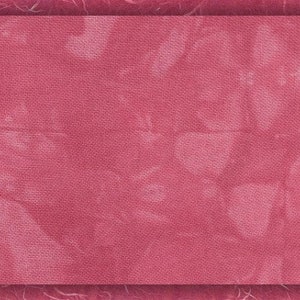 May include: A textured, pink fabric background with a subtle, faded pattern.