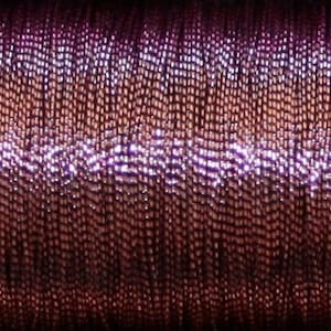 May include: A spool of metallic thread with a gradient of purple, pink, and silver.