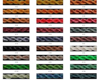 May include: A color chart of embroidery floss with 18 different colors. The floss is arranged in rows of three, with each row containing a different color. The colors range from purple to green to blue.