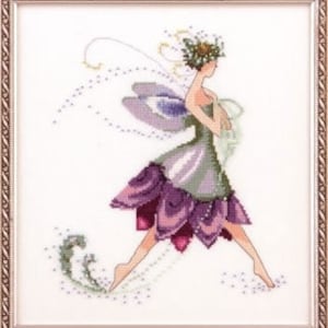 May include: Cross-stitch art of a fairy in a decorative frame. The fairy has purple and green clothing, with a floral crown and wings. The background is white, and the frame is a light brown color.
