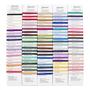May include: A color chart of embroidery floss with 100 different colors. Each color is labeled with a number and a name. The floss is made in France and is 100% silk. It is hand washable and comes in 12 ply, 8 yards.