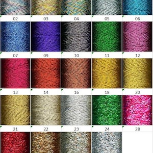 May include: A collection of 16 spools of thread in various colors, including gold, silver, red, green, blue, and purple. The spools are arranged in a grid pattern.