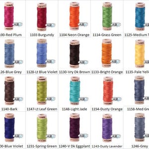 May include: A collection of 18 spools of Aurifil thread in various colours, including red plum, burgundy, neon orange, grass green, medium teal, blue grey, light blue violet, very dark brown, bright orange, pale yellow, bark, leaf green, light jade, dusty orange, medium grey, blue violet, spring green, very dark eggplant, dusty lavender, and grey.